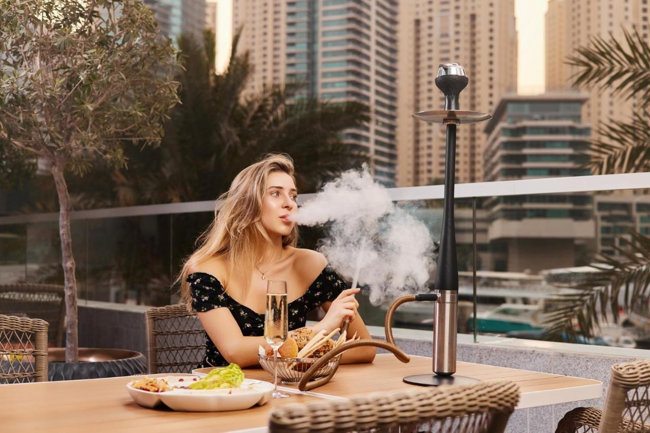 크라운 플라자 두바이 마리나 호텔 외부 사진 A woman smoking a hookah